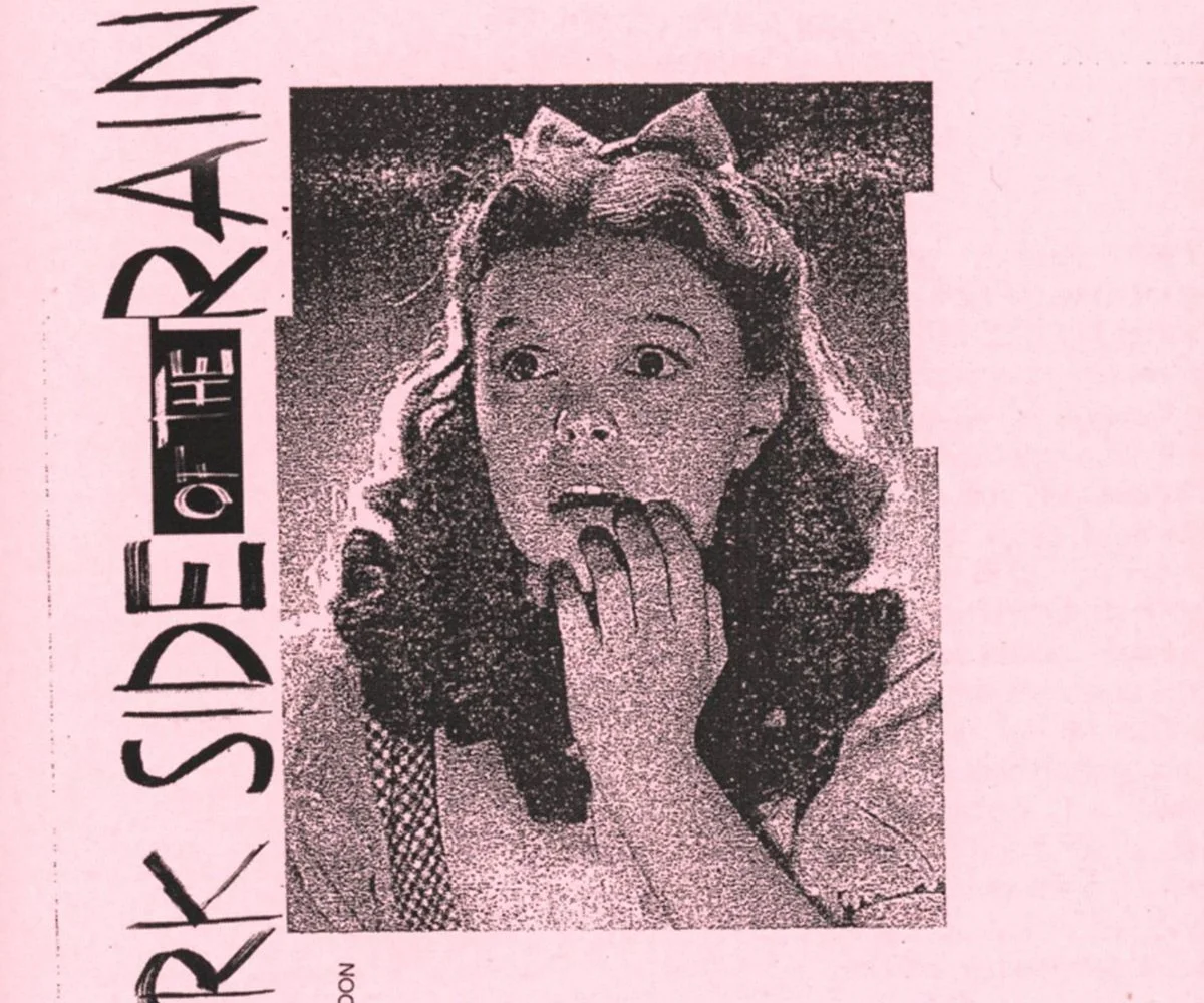 Halftone photograph in pink of a young woman with a bow in her hair, hands at her mouth, the title set vertically beside her.